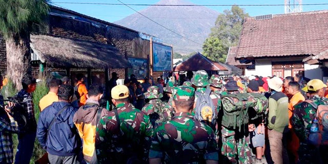 Indonesian soldiers and a rescue team gather to prepare for evacuating tourists from Mount Rinjani.