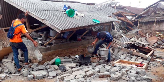 Villagers clear debris caused by an earthquake at Sajang village, Sembalun, East Lombok, Indonesia.