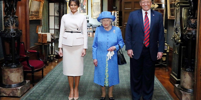 The queen poses for a photo with President Trump and Melania in the Grand Corridor during their visit to Windsor Castle