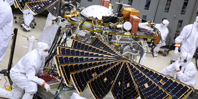 Technicians unfurl the InSight Mars lander's solar arrays during a key test at a Lockheed Martin Space Systems facility in Colorado on Jan. 23, 2018.