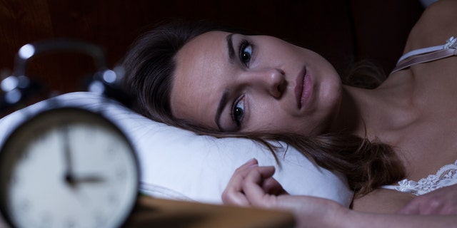 Woman lying in bed suffering from insomnia