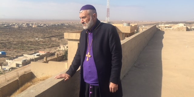 Father Afram looks out at his once vibrant Christian town of Bahzani, Iraq.