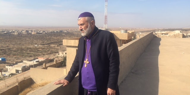 Father Afram looks out at his once vibrant Christian town of Bahzani, Iraq.