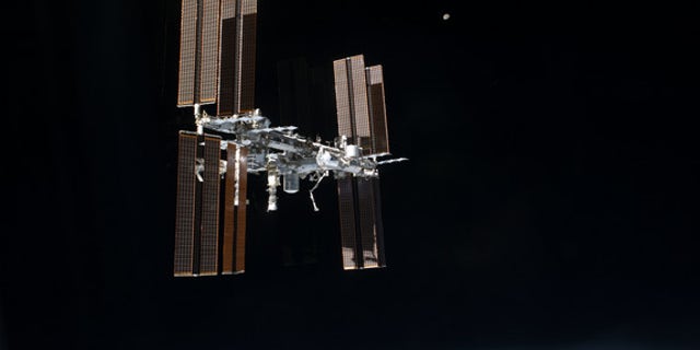 This picture of the International Space Station and the moon was photographed from the space shuttle Atlantis just after the two spacecraft undocked on July 19, 2011, during NASA's final shuttle mission STS-135.