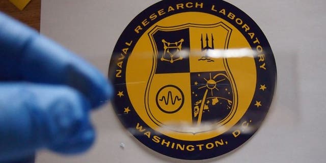 The NRL-developed transparent polymer armor consists of alternating layers of elastomeric polymer and a harder material substrate. Very small crystalline domains, which also provide rigidity, give the polymer its transparency.
