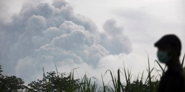 Feb. 14, 2014: A man watches from Mbaladak village in Blitar, East Java, Indonesia, as Mount Kelud erupts.