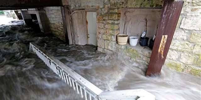 Floodwater pours into the basement of Schera's Algerian American Restaurant & Bar, in Elkader, Iowa, on Aug. 26, 2016. (Mike Burley/Telegraph Herald via AP)