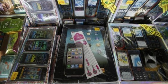 Paper replicas of first generation iPads and iPhones sit on a shelf among other electronic gadgets for sale for the Chinese Qingming festival or Ancestors Day at a prayer supplies shop in Petaling Jaya outside Kuala Lumpur.