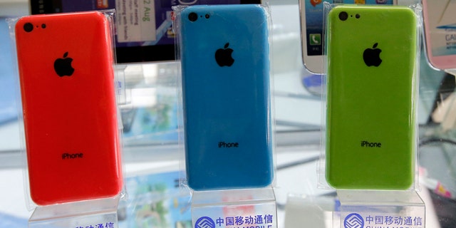 On December 23, 2013, Apple's iPhone 5Cs phone is on display in a rack bearing the China Mobile logo at a mobile phone shop in Beijing.