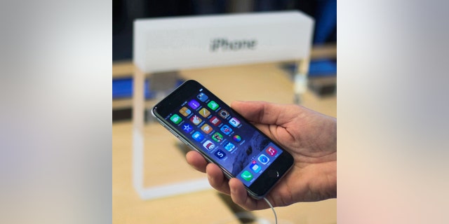 File photo - A customer holds an iPhone 6 on display at the Fifth Avenue Apple store on the first day of sales in Manhattan, New York Sept. 19, 2014. (REUTERS/Adrees Latif)