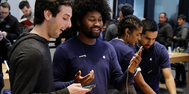 File photo: An Apple sales associate speaks with a customer waiting to purchase a new iPhone X in New York, U.S., November 3, 2017. (REUTERS/Lucas Jackson)