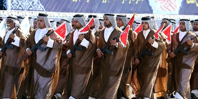 Iranian Arabs who are members of the paramilitary Basij force march in a military parade marking the 37th anniversary of Iraq's 1980 invasion of Iran, in front of the shrine of late revolutionary founder Ayatollah Khomeini, just outside Tehran, Iran, Friday, Sept. 22, 2017.