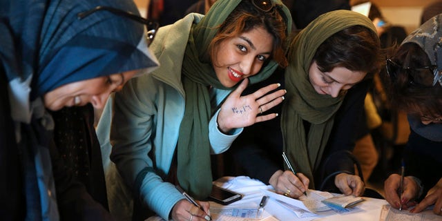 Feb. 26, 2016: An Iranian voter shows her hand with numbers 30+16, a reformists slogan urging people to vote all reformists and moderate candidates in Tehran for both parliament and Assembly of Experts during the elections, as she fills out her ballot in a polling station in Tehran, Iran.