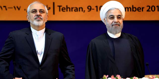 Dec. 9, 2014: Iranian President Hassan Rouhani, right, and Foreign Minister Mohammad Javad Zarif listen to the Iranian national anthem ahead of the "World Against Violence and Extremism," conference.