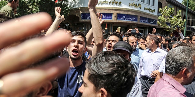 A group of protesters chant slogans at the main gate of old grand bazaar in Tehran, Iran, Monday, June 25, 2018