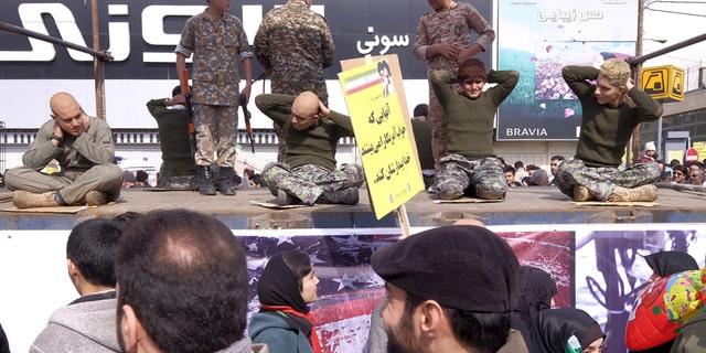 Feb. 11, 2016: Iranian students re-enact a scene from the arrest of American sailors by Iran's Revolutionary Guard, during a ceremony marking the 37th anniversary of the Islamic Revolution, in Tehran.