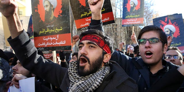 Iranian demonstrators chant slogans during a protest denouncing the execution of Sheikh Nimr al-Nimr, a prominent opposition Shiite cleric in Saudi Arabia, seen in posters, in front of the Saudi Embassy, in Tehran, Sunday, Jan. 3, 2016. Saudi Arabia announced the execution of al-Nimr on Saturday along with 46 others. His execution drew condemnation from Shiites across the region. (AP Photo/Vahid Salemi)