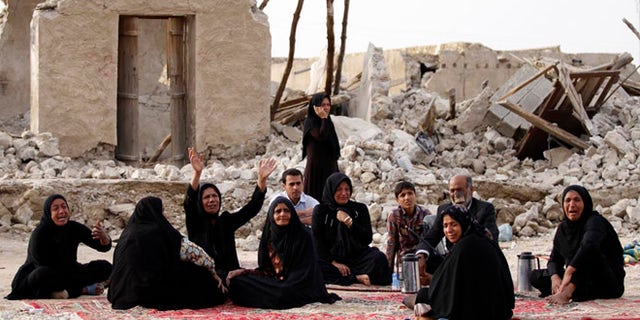 April 10, 2013: Survivors mourn for their loved ones who were killed in Tuesday's earthquake in front of the ruins of their houses, at the city of Shonbeh, southern Iran. A 6.1 magnitude earthquake killed dozens and injured hundreds more in a sparsely populated area in southern Iran on Tuesday, Iranian officials said, adding that it did not damage a nuclear plant in the region.