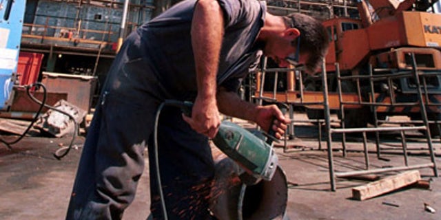 In this Sept. 27, 2000 file photo, an Iranian oil worker repairs a pipe at an oil refinery in Tehran. Iran has halted oil shipments to Britain and France, the Oil Ministry said Sunday, in an apparent pre-emptive blow against the European Union after the bloc imposed sanctions on Iran's crucial fuel exports.