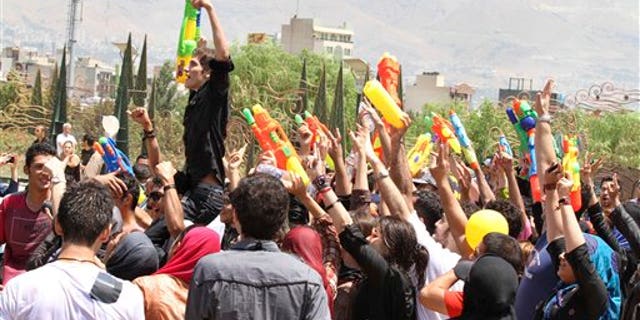 In this picture taken on Friday, July 29, Iranian youths celebrate with their water guns, during their water fights at the Water and Fire Park in northern Tehran, Iran. Iran is trying to put down a new wave of civil disobedience - flash mobs of young people who break into boisterous fights with water guns in public parks.