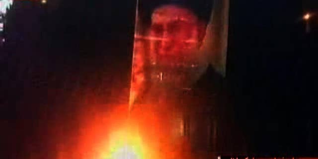 Photo of the Ayatollah is burned during recent protests in Iran.