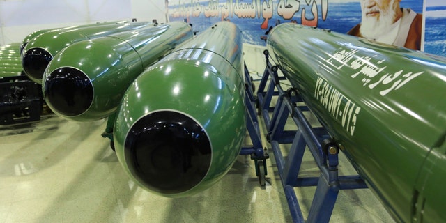 This picture released by the official website of the Iranian Defense Ministry on Tuesday, Oct. 13, 2015, shows ValFajr torpedoes in an undisclosed location. Iran's state TV said the country has successfully test-fired the advanced torpedo system. A portrait of late Iranian revolutionary founder Ayatollah Khomeini is seen at right. (Iranian Defense Ministry via AP)