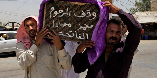 July 1, 2014: Mourners carry the coffin of a victim of violence before his burial in the Shiite holy city of Najaf, 100 miles south of Baghdad, Iraq. Violence has claimed the lives of 2,417 Iraqis in June, making it the deadliest month so far this year, the United Nations said on Tuesday, underlining the daunting challenge the government faces as it struggles to confront Islamic extremists who have seized large swaths of territory in the north and west. Arabic on the coffin reads, "they stood for the late Mohammed Mosawel."