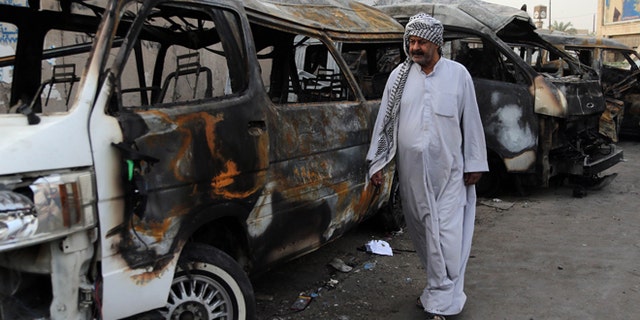 Oct. 12, 2014: A man looks at the site of a car bomb attack in the Shula neighborhood of Baghdad, Iraq.