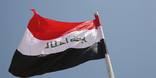 An Iraqi flag waves in the wind above the Iraqi Trebil border crossing.