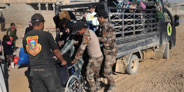Nov. 23, 2016: Iraqi special forces soldiers help a handicapped woman, center, fleeing with her family the fighting between the Islamic State militants and Iraqi forces, in the Al-Samah neighborhood, in Mosul, Iraq.