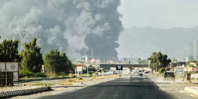 July 31, 2014: In this file photo, a column of smoke rises from an oil refinery in Beiji, some 155 miles north of Baghdad, Iraq, after an attack by Islamic militants. (AP)