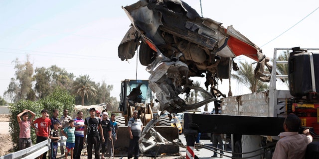 September 9, 2012: A destroyed car is moved from the scene of a car bomb attack in the town of Taji, about 12 miles north of Baghdad, Iraq.