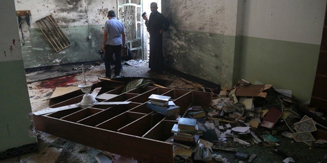 Aug. 25, 2014: Iraqis inspect the damage from an attack on the Imam Ali mosque in New Baghdad, Iraq. (AP/Khalid Mohammed)
