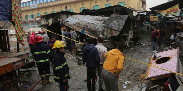Iraqi people gather at the site of bomb attack in a busy market area in Baghdad's central al-Sinek neighborhood, Iraq, Saturday, Dec 31, 2016. (AP Photo/ Karim Kadim)