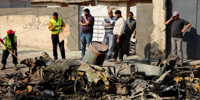 Jan. 15, 2014: Baghdad municipality workers clean up as civilians inspect the site of a car bomb attack near the Technology University in Sinaa Street in downtown Baghdad, Iraq.