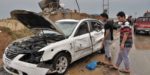 April 13, 2014: Iraq civilians inspect the site of a suicide car bombing in the northern town of Dibis, near the city of Kirkuk, 180 miles north of Baghdad, Iraq.