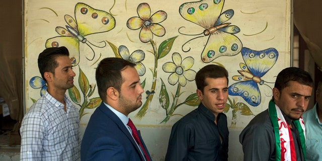 People wait in line at a polling station at a primary school to vote in the Kurdish referendum on independence, in the disputed city of Kirkuk, Monday Sept. 25, 2017. Millions are expected to vote on Monday in Iraq's Kurdish-run provinces and disputed territories as Iraqi Kurds cast ballots in support for independence from Baghdad in a historic but non-binding vote. (AP Photo/Bram Janssen)