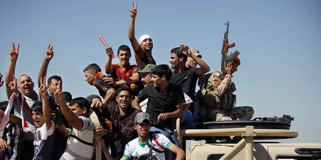 June 17, 2014: Iraqi men flash victory signs as they leave the main recruiting center to join the Iraqi army in Baghdad, Iraq, after authorities urged Iraqis to help battle insurgents. (AP)