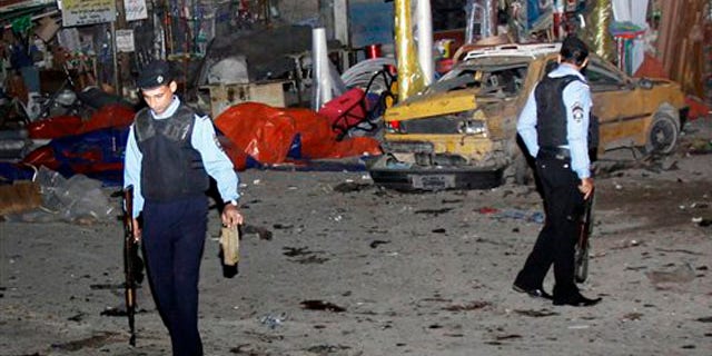 Police inspect the scene of a bomb attack in Basra, 340 miles southeast of Baghdad, Iraq, Thursday, Nov. 24, 2011.
