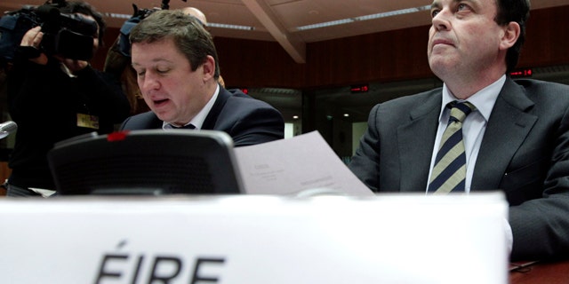 Nov. 28: Irish Finance Minister Brian Lenihan, right, waits for the start of a round table meeting of EU finance ministers at the EU Council building in Brussels. Finance ministers from the eurozone and the EU are met in Brussels Sunday to agree on a financial aid package for Ireland. (AP)