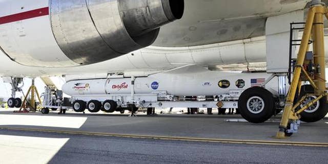 This image shows technicians and engineers at Vandenberg Air Force Base in California connecting the Pegasus XL rocket with the Interface Region Imaging Spectrograph, or IRIS, solar observatory to the Orbital Sciences L-1011 carrier aircraft.