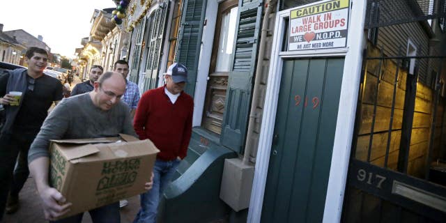 Jan. 18, 2015: Men walk past a sign encouraging people to walk in large groups, in the French Quarter of New Orleans.