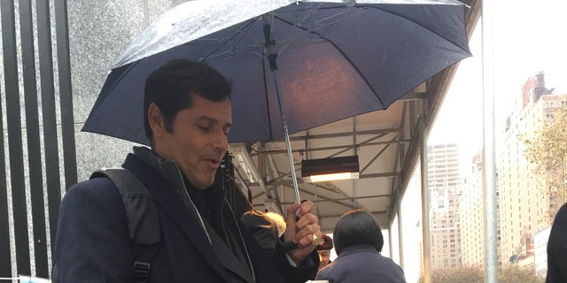 Isaias Medina waiting outside the United Nations as Security guards take the unusual step of calling their superiors to get permission to allow him to enter.