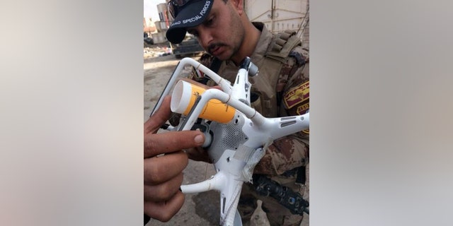 Iraqi Counter Terrorism Service soldier in Mosul examines an ISIS drone modified to carry a 40mm rifle grenade in the attached plastic tube. Grenade is dropped when the drone is over Iraqi forces.