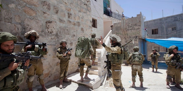 June 15, 2014: Israeli soldiers patrol during a military operation to search for three missing teenagers outside the West Bank city of Hebron. Israeli troops on Sunday arrested some 80 Palestinians, including dozens of members of Hamas, in an overnight raid in the West Bank as Prime Minister Benjamin Netanyahu accused the Islamic militant group of kidnapping three teenagers who went missing nearly three days ago. (AP/Majdi Mohammed)