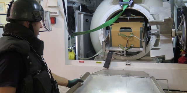 An Israeli Police explosives expert examines the grenade discovered at the Haganah Museum (Israel Police).