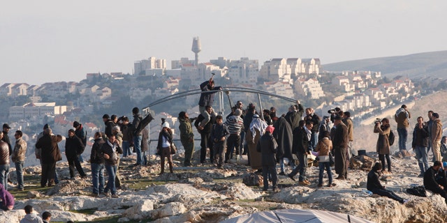 Jan 11, 2013: Palestinians, together with Israeli and foreign activists, stand near newly-erected tents in an area known as E1 at the settlement of Ma'aleh Adumim, near Jerusalem.
