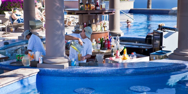 Bartenders work around a pool bar in Cabo San Lucas.