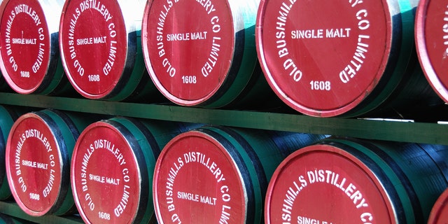 Bushmills, County Antrim, Northern Ireland - June 9, 2013: Barrels of Old Bushmills Irish Whiskey are stacked at the entrance to the Distillery. Founded in 1743 it hosts over 120,000 visitors a year.