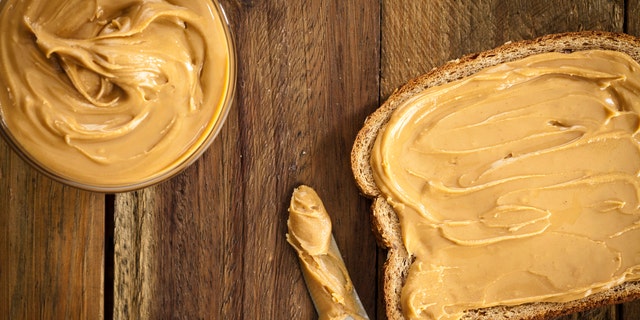Peanut butter spread across a piece of bread. It's wise to swap any kind of nut butter — peanut, almond, sunflower and others — for unsalted and no-sugar-added nut butter, said one nutrition expert. 